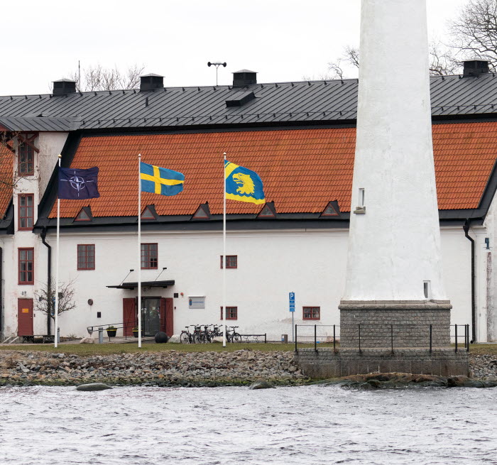 Natos flagga, svenska flaggan och Kustbevakningens flagga vajar på Stumholmen, Karlskrona.