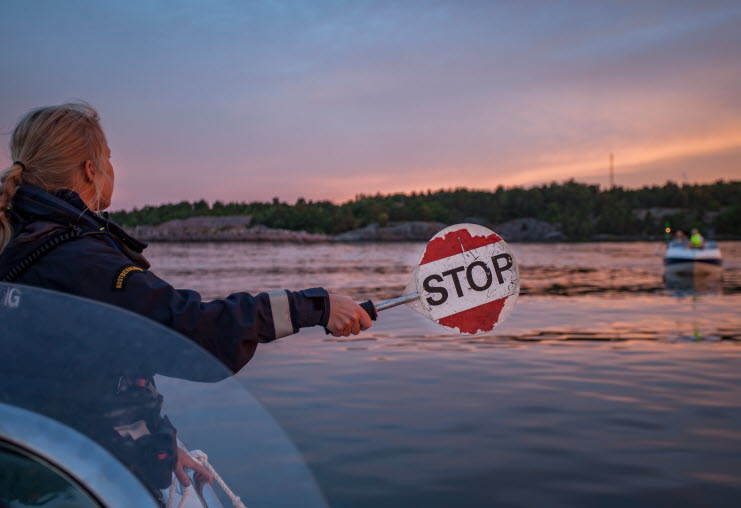 Kustbevakare använder stoppskylt i samband med sjötrafikövervakning