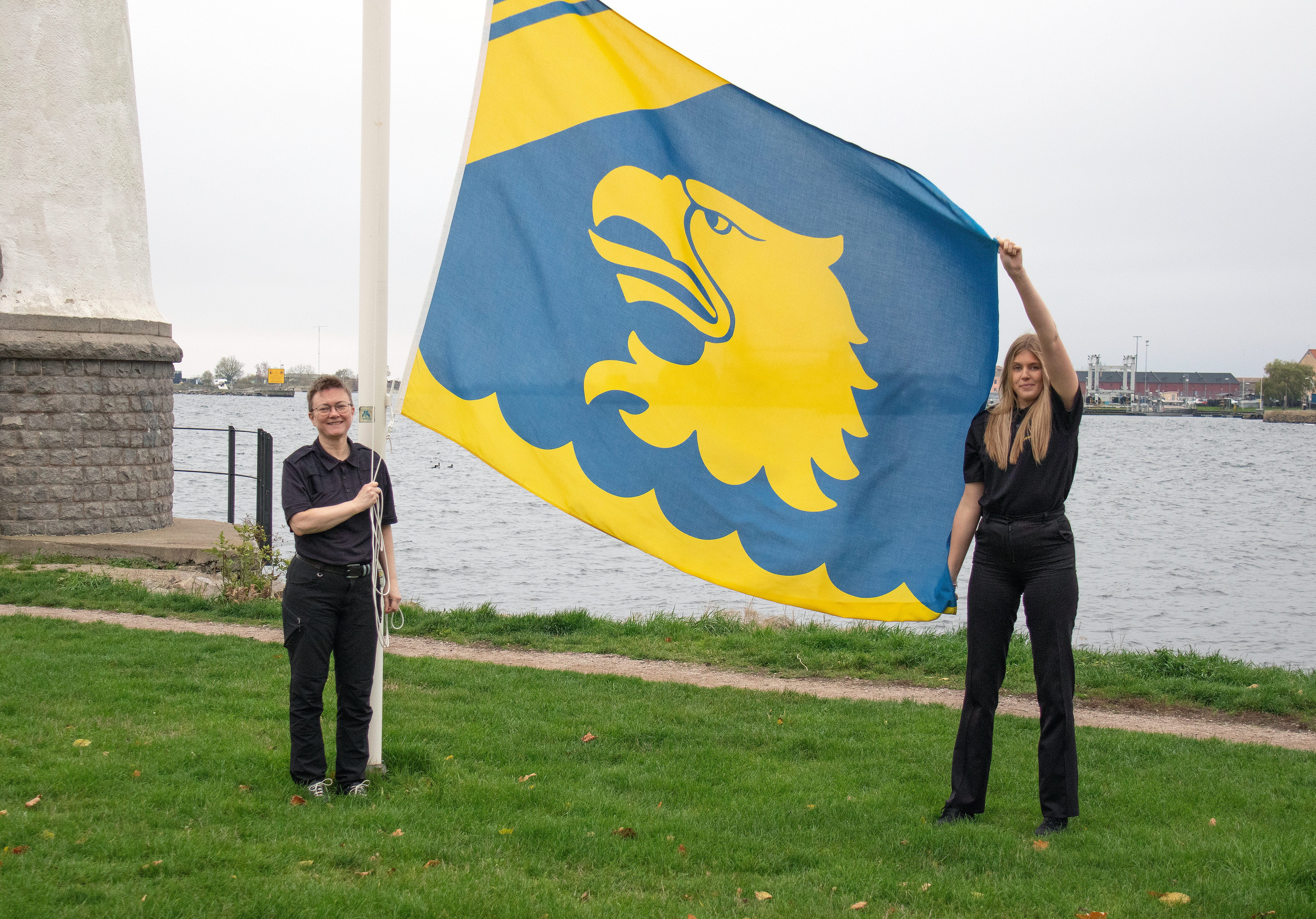Annika och Maja hissar Kustbevakningens flagga på Stumholmen i Karlskrona
